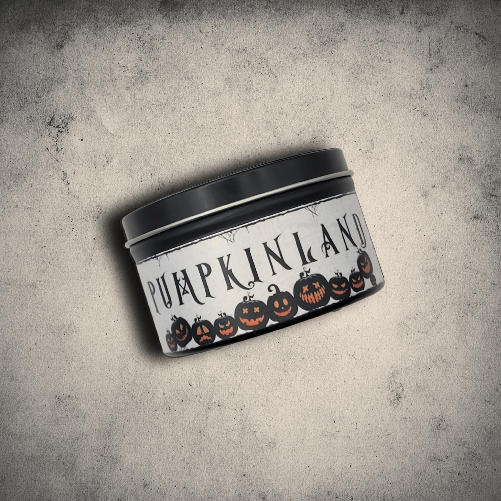 8oz Pumpkinland seasonal pumpkin pie soy candle in a black tin against a textured white and gray stone background.